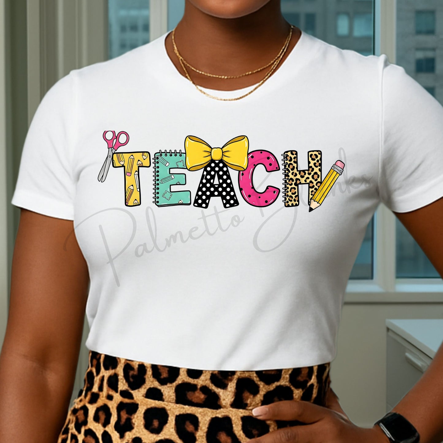 White t-shirt featuring the “TEACH” design with colorful school supply-themed letters including scissors, notebook, bow, leopard print, and pencil in a full color screen print style.