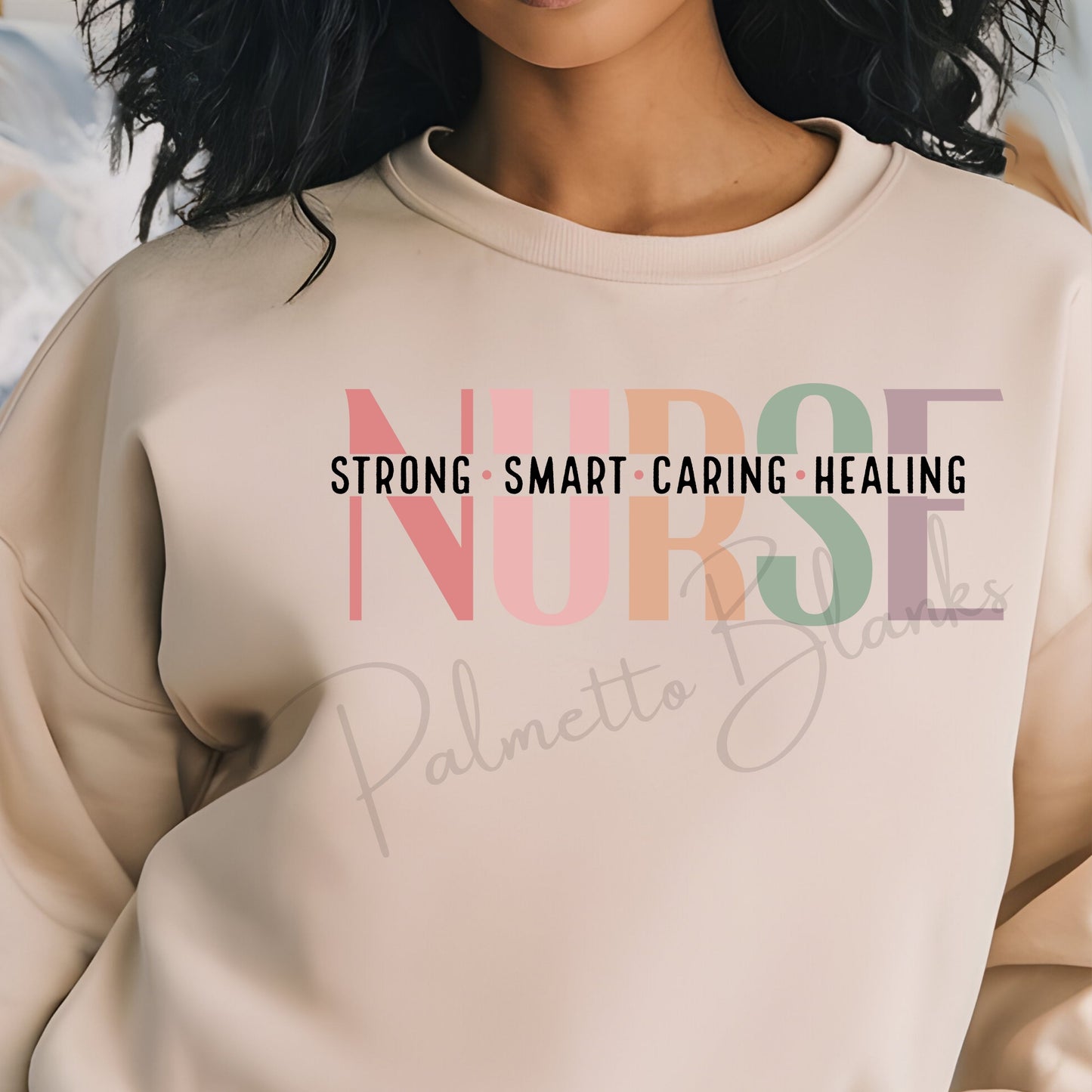 Beige sweatshirt with “NURSE” design in soft multicolor block letters and bold black text reading “Strong • Smart • Caring • Healing” across the chest.