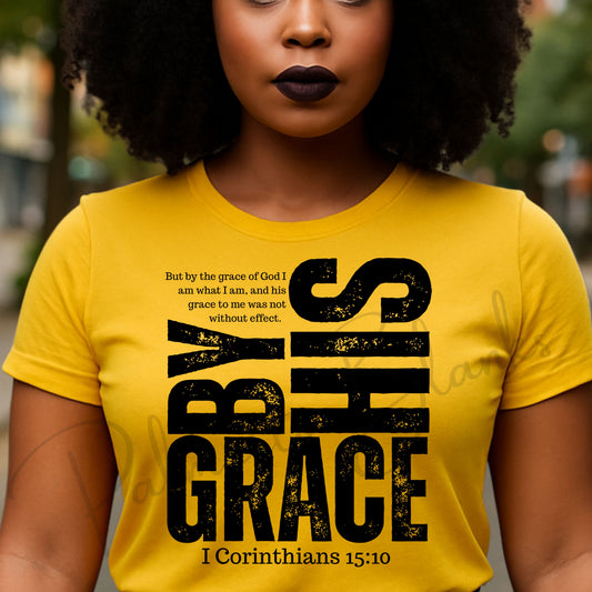 “By His Grace” 1 Corinthians 15:10 white distressed scripture design on a black t-shirt, ideal for screen print transfers.