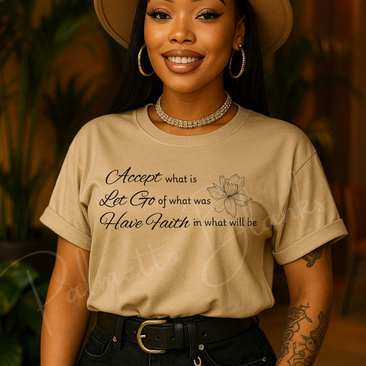 Tan t-shirt featuring the inspirational quote “Accept what is, Let Go of what was, Have Faith in what will be” in elegant script with a lotus flower line art.