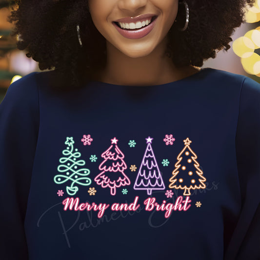 Navy sweatshirt featuring “Merry and Bright” in neon-style script with four colorful neon Christmas trees and snowflakes, ideal for holiday full color screen print transfers.