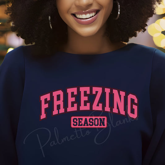 Navy sweatshirt with “Freezing Season” design in bold varsity pink block letters, ideal for winter apparel full color screen print transfers.